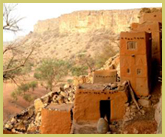 View along the sandstone escarpment showing traditional granaries built under shelter at the foot of the cliffs at the Cliff of Bandiagara - Land of the Dogons world heritage site in Mali