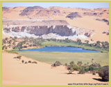 View of one of the lakes in the Ounianga Serir group, showing extensive encroachment of its waters by freshwater reeds and rocky hills rising steeply behind