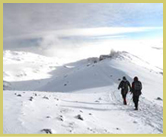 Trudging through the snow along the rim of Kibo crater on the final approach to Uhuru Peak, the summit of Kilimanjaro National Park world heritage site