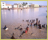 Bathing in the channel on the seaward side of the Island of Saint-Louis UNESCO world heritage site, Senegal